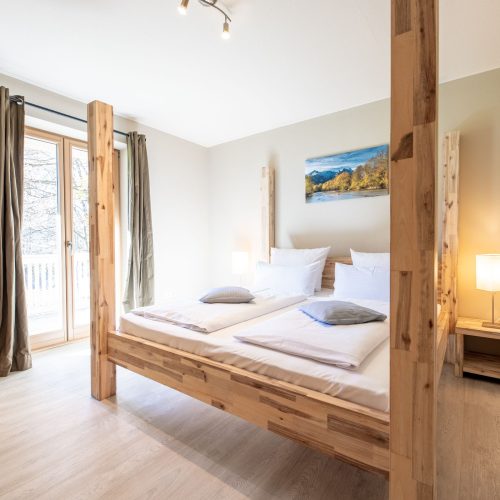 Bett mit Holzbalken in Ferienwohnung in Garmisch-Partenkirchen