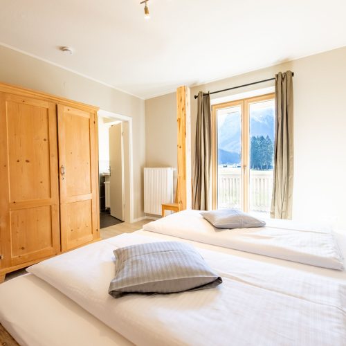 Ein Doppelbett und ein Kleiderschrank in Ferienwohnung in Garmisch-Partenkirchen