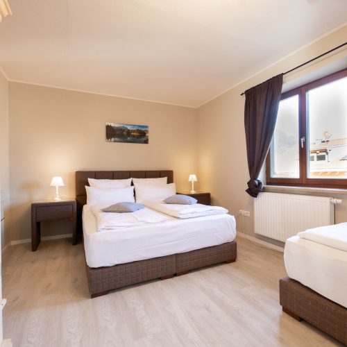 Schlafbereich mit dunklen Vorhängen in Ferienwohnung in Garmisch-Partenkirchen