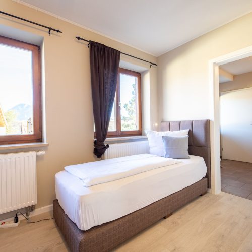 Einzelbett mit Tür zum Flur in Ferienwohnung in Garmisch-Partenkirchen