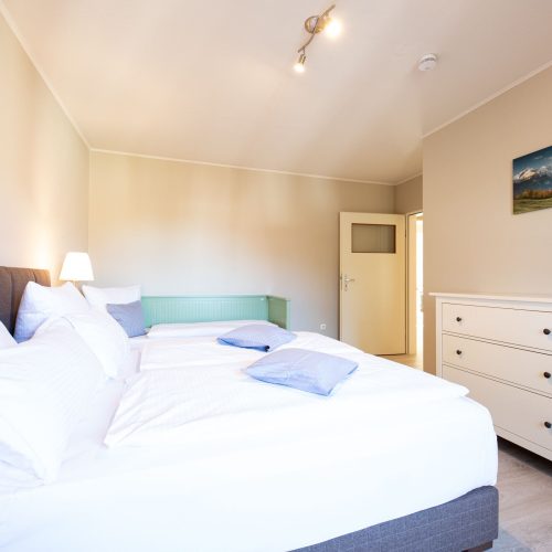 Schlafzimmer mit weißer Kommode in Ferienwohnung in Garmisch-Partenkirchen