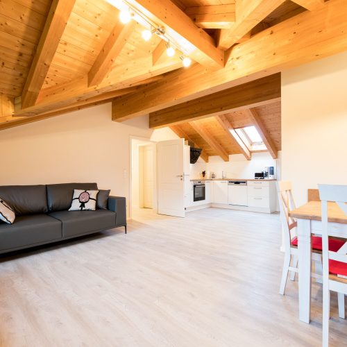 Wohnbereich mit Sofa in schwarz und Tisch in Ferienwohnung in Garmisch-Partenkirchen