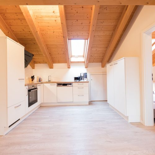 Küche in weiß unter einer Schräge in Ferienwohnung in Garmisch-Partenkirchen