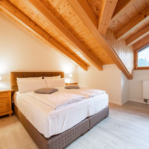 Doppelbett mit Nachttisch in Ferienwohnung in Garmisch-Partenkirchen