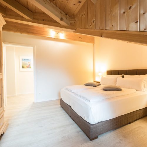 graues Doppelbett mit Schräge in Ferienwohnung in Garmisch-Partenkirchen