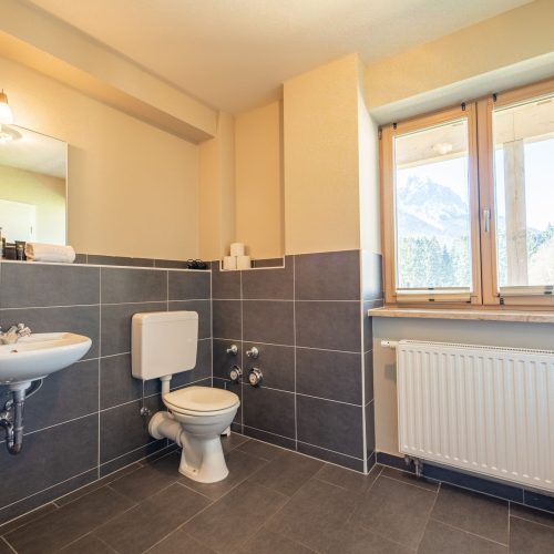 Badezimmer mit grauen Fliesen in Ferienwohnung in Garmisch-Partenkirchen