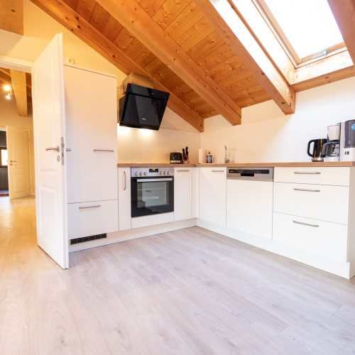 Küche mit Tür zum Flur in weiß in Ferienwohnung in Garmisch-Partenkirchen