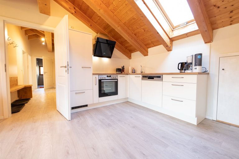 Küche mit Tür zum Flur in weiß in Ferienwohnung in Garmisch-Partenkirchen