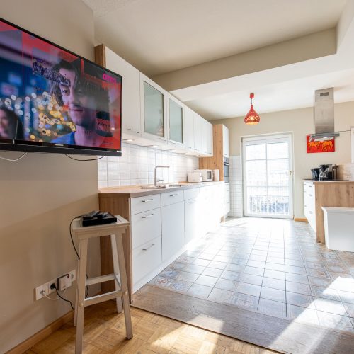 Durchgang vom Wohnzimmer in die Küche mit Fernseher in Ferienwohnung in Garmisch-Partenkirchen