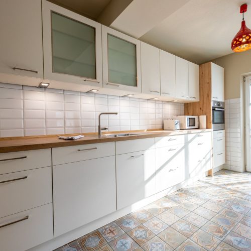 Küche mit weißen Schränken in Ferienwohnung in Garmisch-Partenkirchen