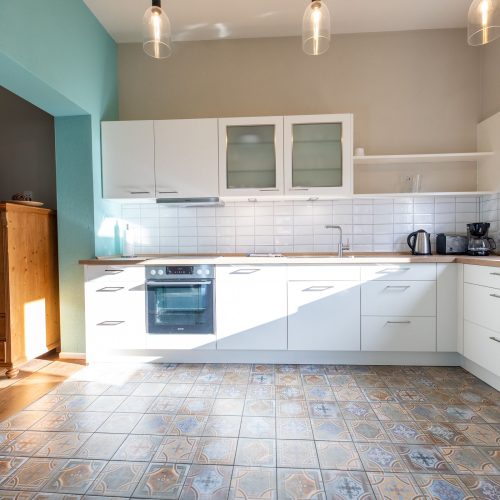 Küchenbereich mit einer hell blauen Wand in Ferienwohnung in Garmisch-Partenkirchen