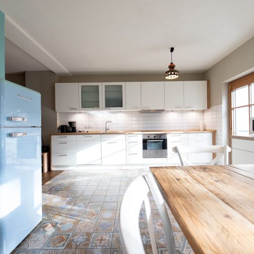 Küche mit weißen Regalen in Ferienwohnung in Garmisch-Partenkirchen