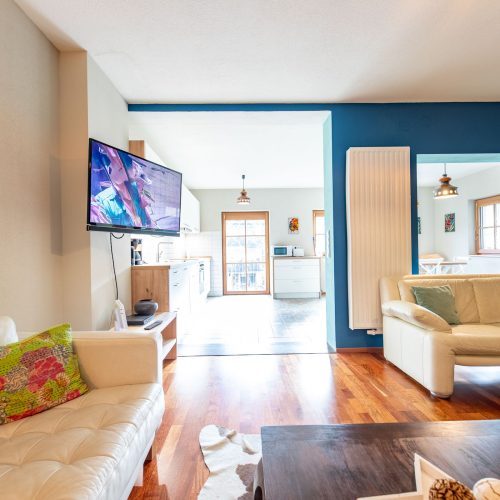 Wohnbereich mit blauen Wänden und Fernseher in Ferienwohnung in Garmisch-Partenkirchen