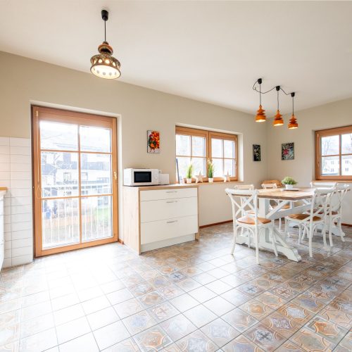 Esszimmer mit einem Esstisch und weißen Holzstühlen in Ferienwohnung in Garmisch-Partenkirchen