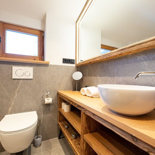 Badezimmer mit Waschbecken und Holz Schränken in Ferienwohnung in Garmisch-Partenkirchen