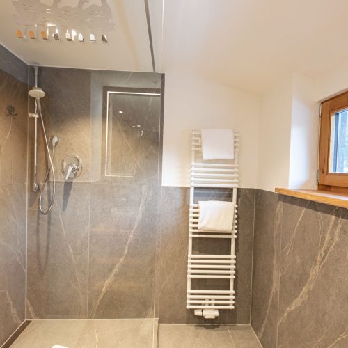 Badezimmer mit Dusche und Fenster in Ferienwohnung in Garmisch-Partenkirchen