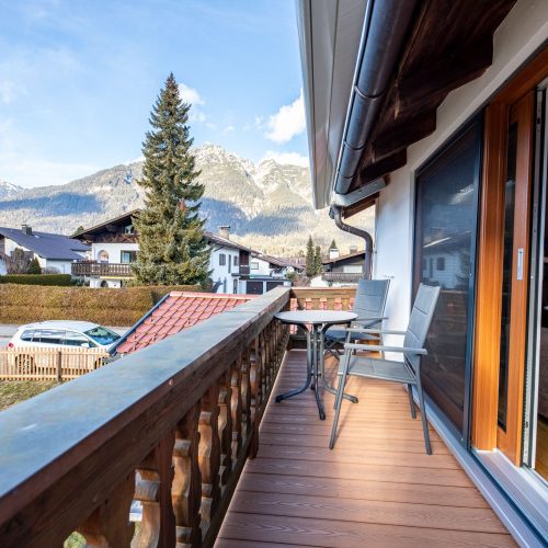 Balkon mit Sitzmöglichkeiten und Tisch in Ferienwohnung in Garmisch-Partenkirchen