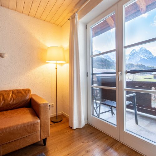 Braunes Sofa mit Fenster in Ferienwohnung in Garmisch-Partenkirchen
