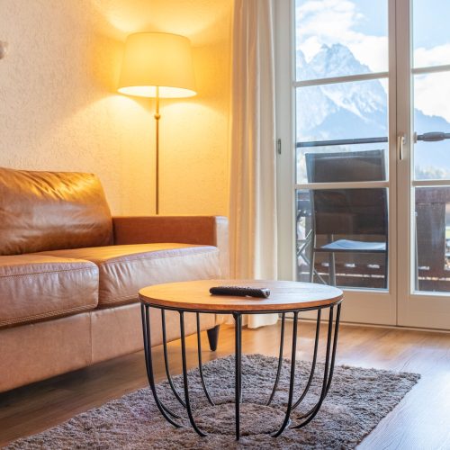 braunes Sofa mit Stehlampe in Ferienwohnung in Garmisch-Partenkirchen
