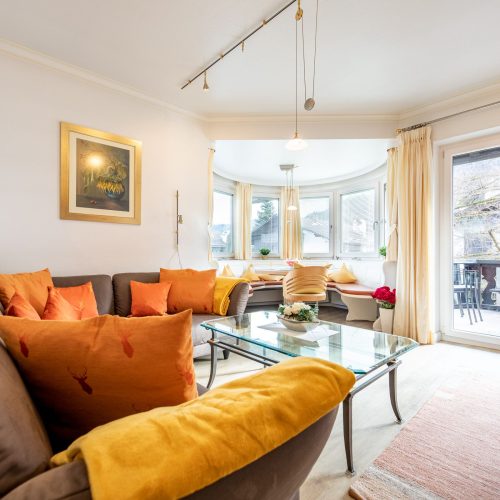 Sofa mit Kissen und Essbereich in Ferienwohnung in Garmisch-Partenkirchen