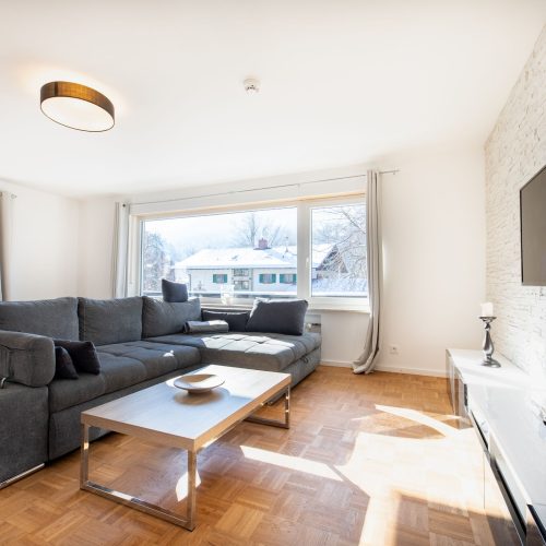 Wohnzimmer mit Fernseher und schwarz weißem Sideboard in Ferienwohnung in Garmisch-Partenkirchen