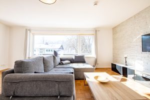 Wohnzimmer mit schwarzem Sideboard und Fernseher in Ferienwohnung in Garmisch-Partenkirchen