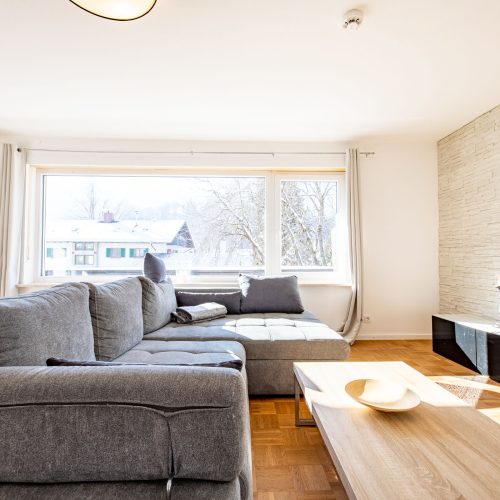 Wohnzimmer mit schwarzem Sideboard und Fernseher in Ferienwohnung in Garmisch-Partenkirchen