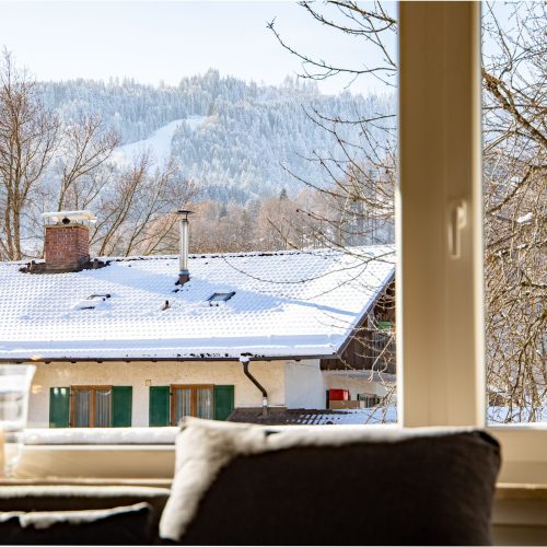 Blick auf die Berge aus dem Wohnzimmer Fenster in Ferienwohnung in Garmisch-Partenkirchen