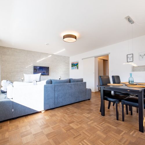 Wohnbereich mit Sofa und Esstisch in Ferienwohnung in Garmisch-Partenkirchen