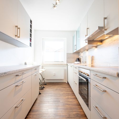 Küche mit vielen Schränken und Herd in Ferienwohnung in Garmisch-Partenkirchen