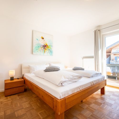 Doppelbett mit Bild und gutem Ausblick in Ferienwohnung in Garmisch-Partenkirchen