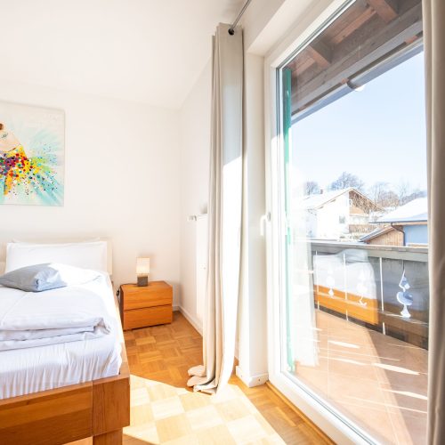 Doppelbettzimmer mit Ausgang zum Balkon und Nachttisch in Ferienwohnung in Garmisch-Partenkirchen