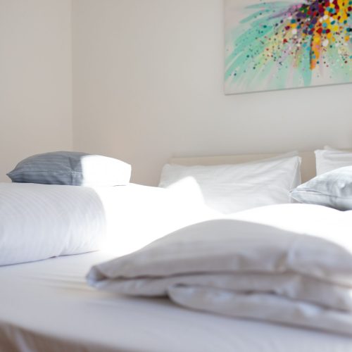 Doppelbett und farbenfrohes Bild in Ferienwohnung in Garmisch-Partenkirchen