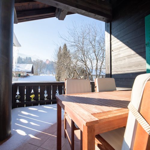 Balkon mit Sitzmöglichkeit und kleinem Tisch in Ferienwohnung in Garmisch-Partenkirchen