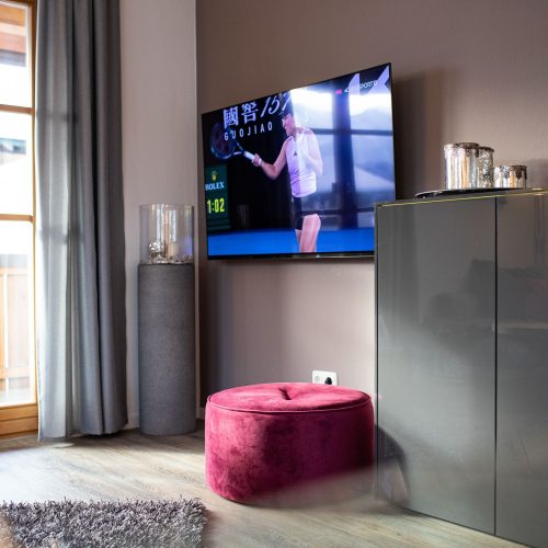 Wohnzimmer mit dunkler Wand und Fernseher in Ferienwohnung in Garmisch-Partenkirchen