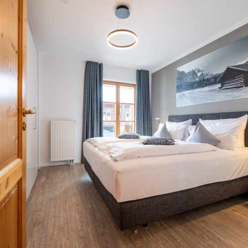 Doppelbettzimmer mit einem großen Bild in Ferienwohnung in Garmisch-Partenkirchen