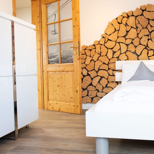 Einzelbett mit einer Holz gemusterten Wand in Ferienwohnung in Garmisch-Partenkirchen
