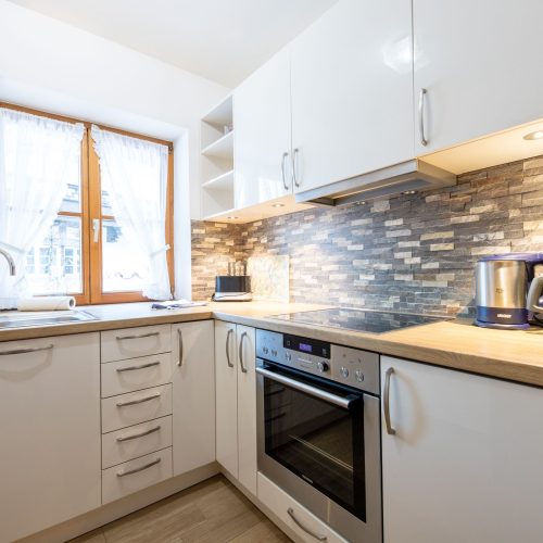 Küche mit Backofen und Fenster in Ferienwohnung in Garmisch-Partenkirchen