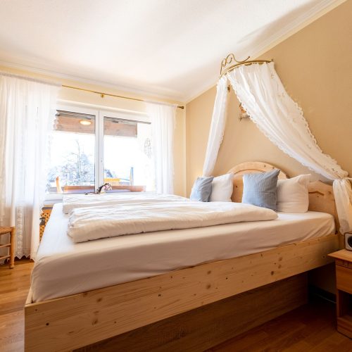 Doppelbett und Nachttisch in Ferienwohnung in Garmisch-Partenkirchen