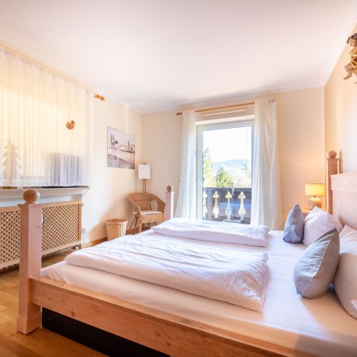 Doppelbett mit Gardienen in Ferienwohnung in Garmisch-Partenkirchen