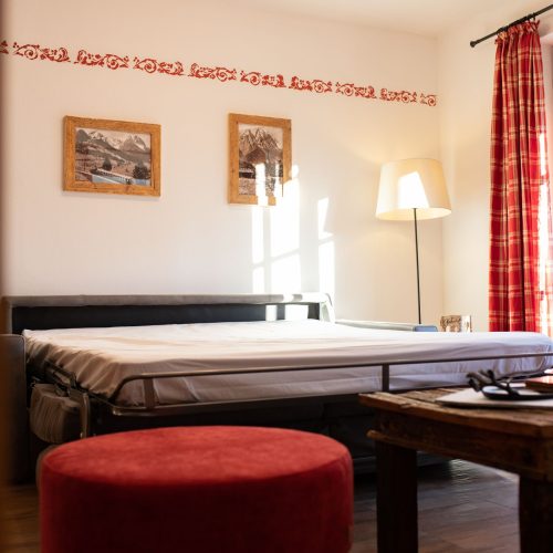 Schlafzimmer mit roten Akzenten in Ferienwohnung in Garmisch-Partenkirchen