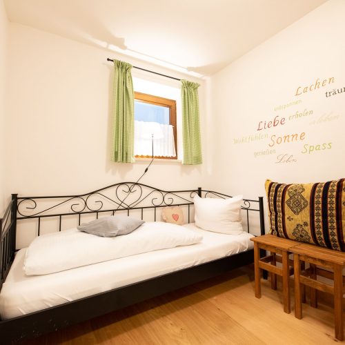 Einzelbett mit Gardinen in Ferienwohnung in Garmisch-Partenkirchen