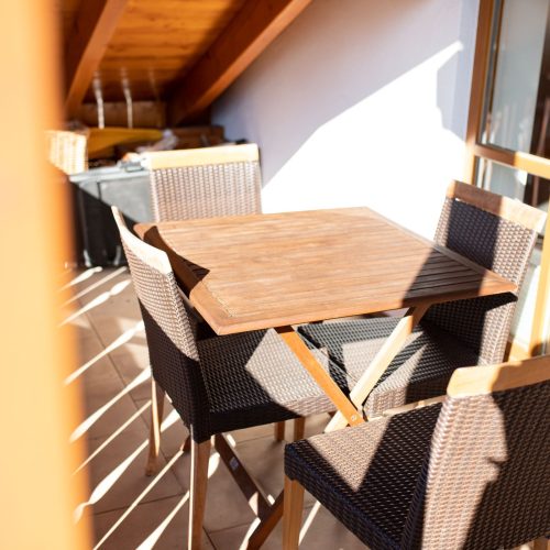 Balkon mit kleinem Tisch und vier Stühlen an Ferienwohnung in Garmisch-Partenkirchen