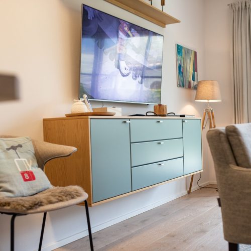 Sideboard und Fernseher mit Stuhl in Ferienwohnung in Garmisch-Partenkirchen