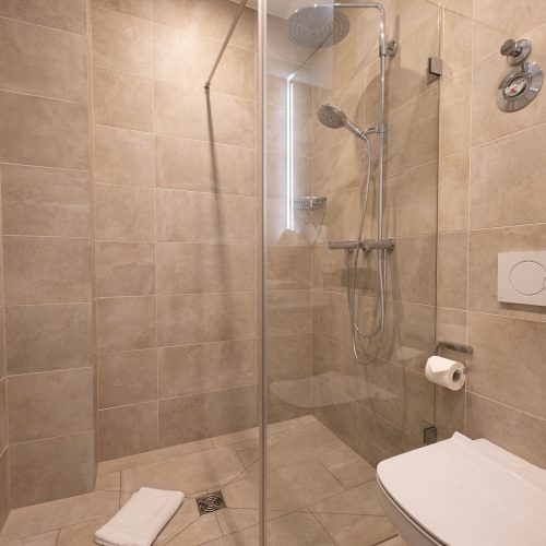 Beige-braunes Badezimmer mit großer Regenfalldusche
