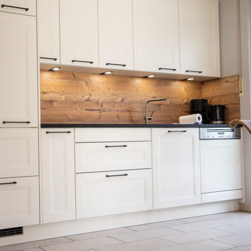 Küche mit schwarzen Arbeitsflächen in Ferienwohnung in Garmisch-Partenkirchen