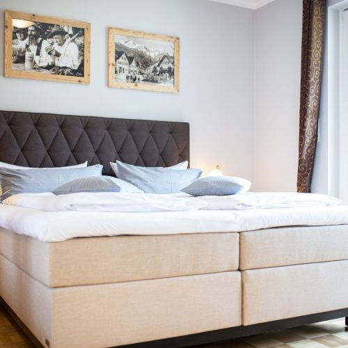 Doppelbett mit einem dunkel grauem Kopfteil in Ferienwohnung in Garmisch-Partenkirchen