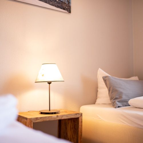 zwei Einzelbetten mit Nachttisch in Ferienwohnung in Garmisch-Partenkirchen