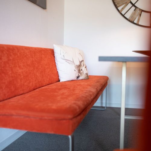 Rotes Sofa mit Hirschkissen in Ferienwohnung in Garmisch-Partenkirchen