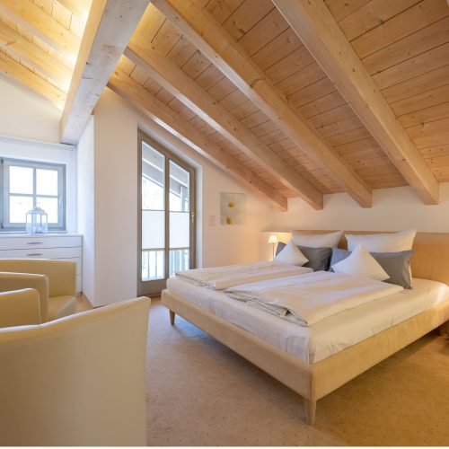 Doppelbett und zwei Sessel in Ferienwohnung in Garmisch-Partenkirchen